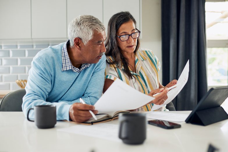 Couple reviewing insurance paperwork together at a kitchen table