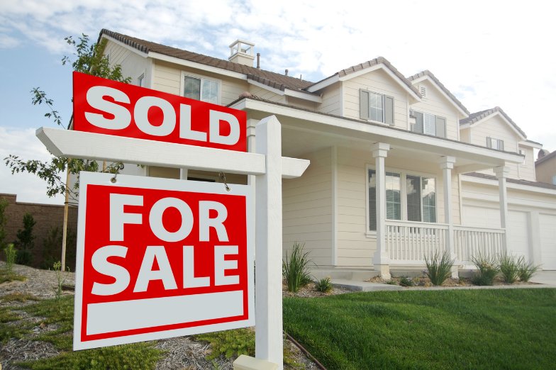 Florida home with a For Sale sign and Sold rider in the front yard
